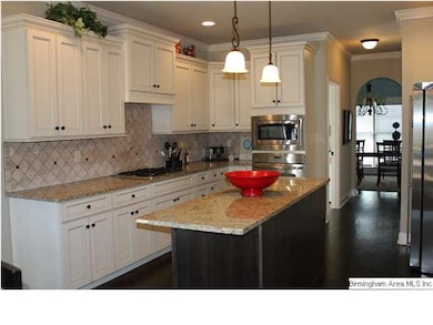 This spacious kitchen has granite counters, tile b