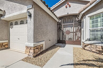 View of exterior entry featuring stone siding, a g