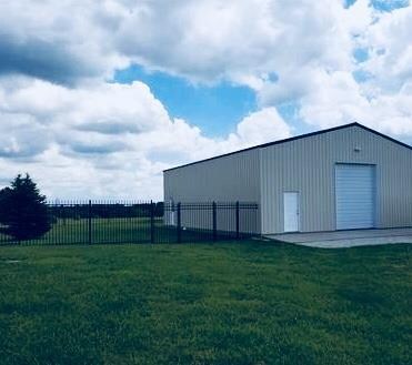 Metal outbuilding has concrete apron, adjoining wr