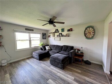 Living room featuring hardwood / wood-style flooring, ceiling fan, and a textured ceiling