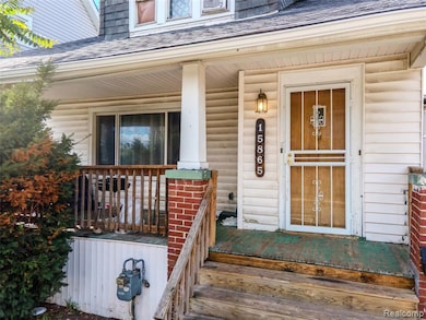 Entrance to property with a shingled roof and a porch