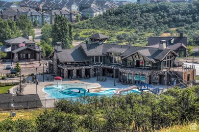 Community pool with a water slide, a patio area, and a residential view