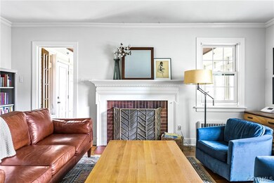 Living room featuring ornamental molding, a brick fireplace, and hardwood / wood-style flooring