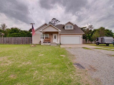 View of front facade featuring a front yard, a gar
