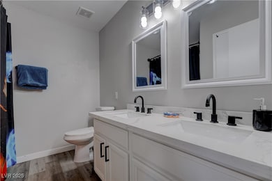 Primary Bathroom with wood finished floors, double