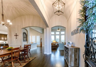 You are welcomed by beautiful wood floors and stunning light fixtures. This wide entrance feels open and welcoming while keeping family spaces private.