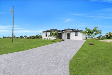 View of front of house with decorative driveway, a