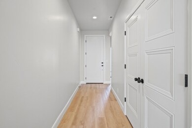 Hall with light wood-style flooring and recessed lighting