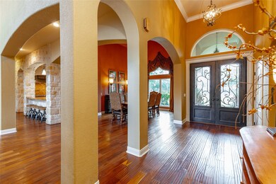 Those exquisite double front doors set the expectation high for this magnificent home that welcomes guests with an elegant foyer featuring a soaring 14' ceiling trimmed with crown molding, designer lighting, and hand-scraped hardwood floors.