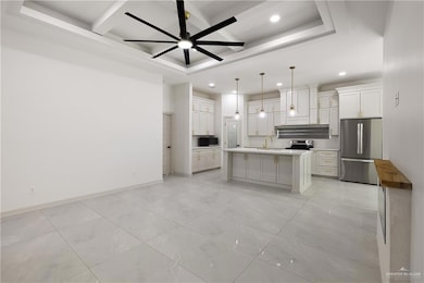 Kitchen featuring coffered ceiling, recessed lighting, light countertops, ceiling fan, and appliances with stainless steel finishes