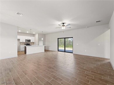 Unfurnished living room featuring ceiling fan, sin