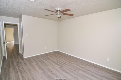 Spare room with ceiling fan, light wood-type flooring, and a textured ceiling