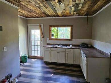 Kitchen with sink, backsplash, white cabinetry, or