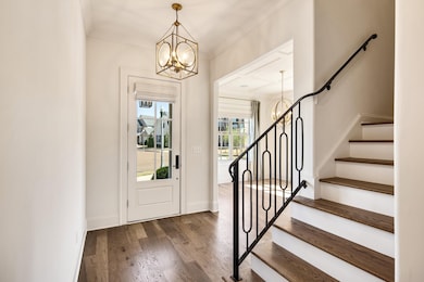 Foyer featuring stairs, baseboards, a chandelier, 