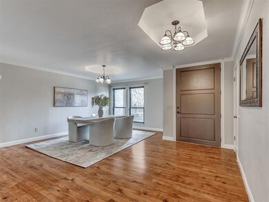 Dining area with a chandelier, light wood finished floors, and crown molding