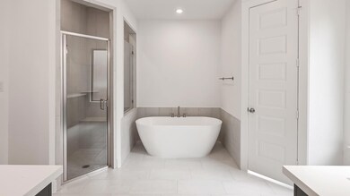 Bathroom featuring a soaking tub, tile patterned 