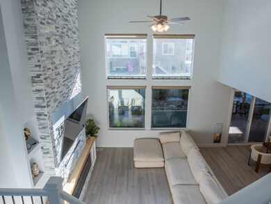 Living room featuring plenty of natural light, wood finished floors, and ceiling fan