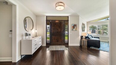 Welcoming entryway with sleek dark wood floors, mo