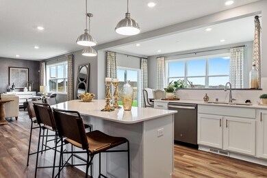 Large extended kitchen island inspires quality family time throughout the day.  Photo is of a previously built home, colors and finishes may vary.
