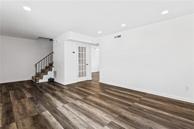 Unfurnished living room featuring stairway, recessed lighting, and dark wood finished floors
