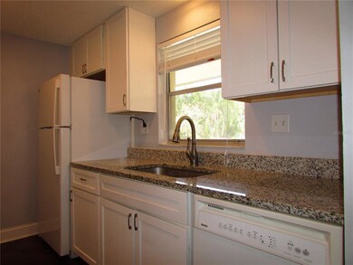 Bright galley-style kitchen with granite counters.