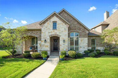 Such gorgeous curb appeal with fresh landscaping, custom stonework & a covered patio!