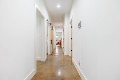 Corridor with concrete floors, recessed lighting, 