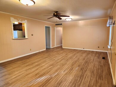Unfurnished room with wooden walls, ceiling fan, ornamental molding, and hardwood / wood-style flooring
