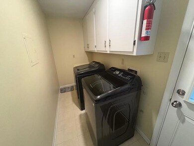 Laundry area with independent washer and dryer, cabinet space, and baseboards