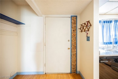 Entry featuring textured ceiling, and wood finishe