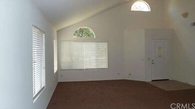 Tile floor entry and living room with soaring ceil