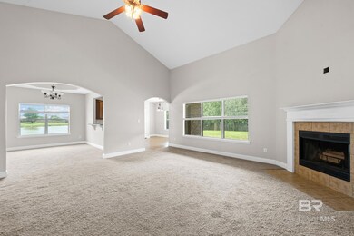 Unfurnished living room featuring carpet floors, high vaulted ceiling, and a tiled fireplace