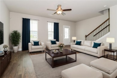 Living room with stairway, a ceiling fan, and wood