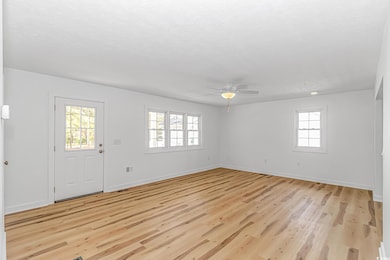 Foyer featuring baseboards, a ceiling fan, and lig