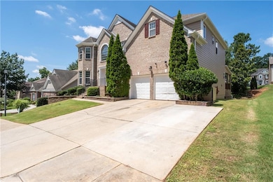 Traditional home featuring brick siding, driveway, a garage, and a front yard
