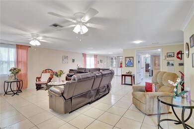 Living area with light tile patterned floors, a ceiling fan, and crown molding