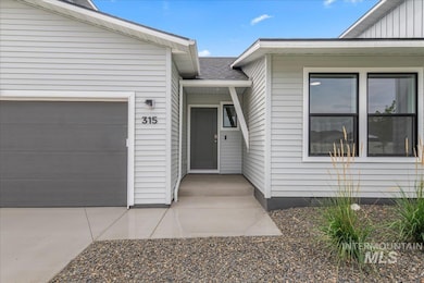 Entrance to property featuring an attached garage and a shingled roof