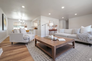 Living room featuring recessed lighting, light wood finished floors, and a chandelier