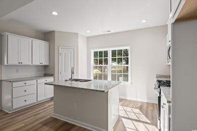 Kitchen with a kitchen island with sink, white cab