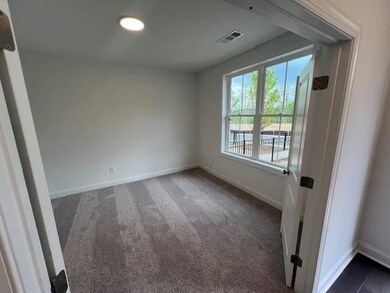 Spare room featuring baseboards and dark carpet
