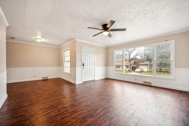 Empty room featuring ceiling fan, dark wood-type f