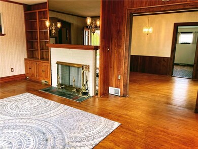 View of living room with original hardwood floors, built ins and gas line to fireplace