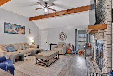 Living area featuring lofted ceiling with beams, l