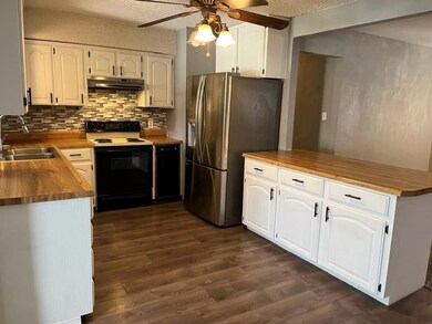 Kitchen UPDATED with glass backsplash, butcher block counters & luxury vinyl floors. Trash compactor, breakfast bar & large pantry. Open to Family Room.