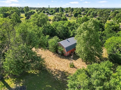 View of subject property featuring a tree filled landscape