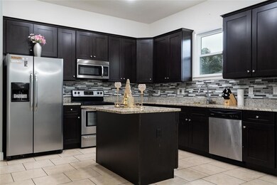 42' cabinets, central island, custom tile backsplash. All appliances convey.