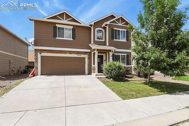 Craftsman-style house with stone siding, an attached garage, concrete driveway, and a front lawn