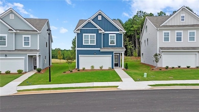 View of front of property with board and batten siding, a front lawn, and a garage