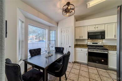 Kitchen featuring vaulted ceiling, dark stone coun