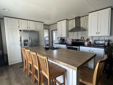 Kitchen featuring wall chimney exhaust hood, a si